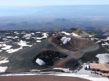 Les cratères Silvestri, sur le versant sud de l’Etna ; à leur pied, le refuge Sapienza et, au loin, la plaine de Catane.