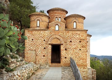 La Cattolica de Stilo, petite église byzantine de brique à cinq coupoles, parmi les figuiers de Barbarie.
