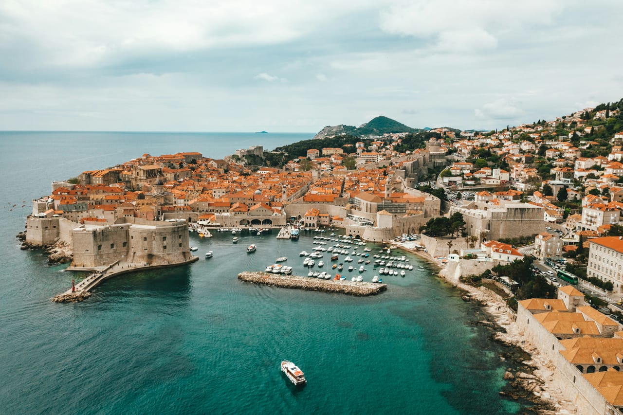 Dubrovnik vue du ciel : le vieux port, le fort Saint-Jean et les toits de la vieille ville.