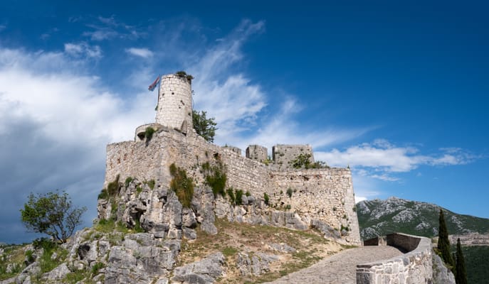 La forteresse de Klis sur son éperon rocheux, sous un ciel d’orage.