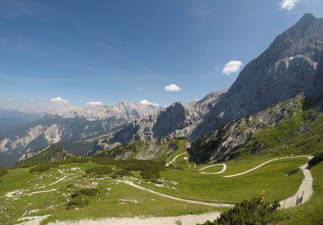 Le massif de la Zugspitze et ses alpages, sous un ciel bleu.