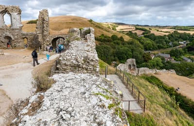 Les ruines de Corfe Castle au-dessus du village et des collines de Purbeck.