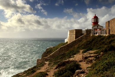 Le phare du cap Saint-Vincent dans ses murailles, au-dessus d’une mer agitée.