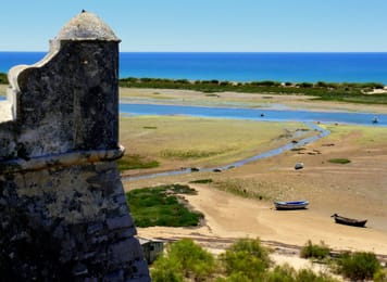 La Ria Formosa à marée basse, vue de la forteresse de Cacela Velha : chenaux, barques échouées et, au loin, l’île-barrière.