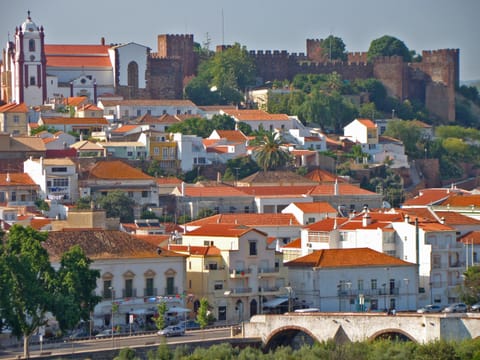 Silves au-dessus de l’Arade : la cathédrale, les remparts de grès rouge du château et le vieux pont.