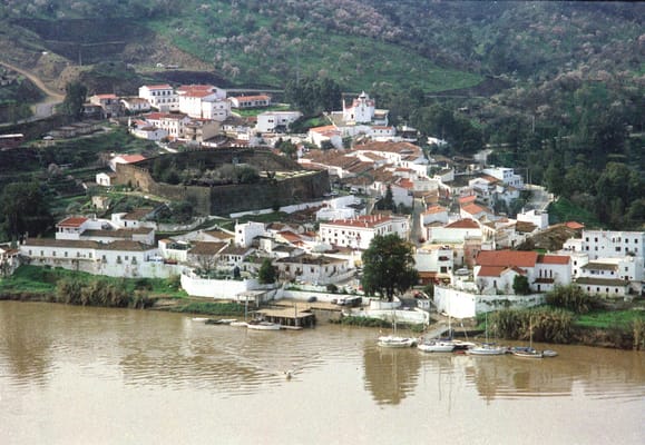 Alcoutim vu de la rive espagnole : le village blanc, son château et les voiliers sur le Guadiana.