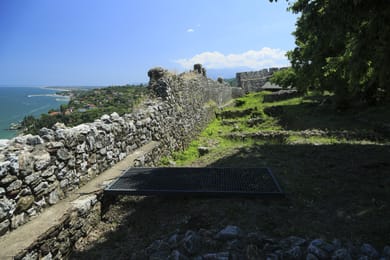 Les murailles du château de Platamonas au-dessus de la mer, sous un ciel bleu.