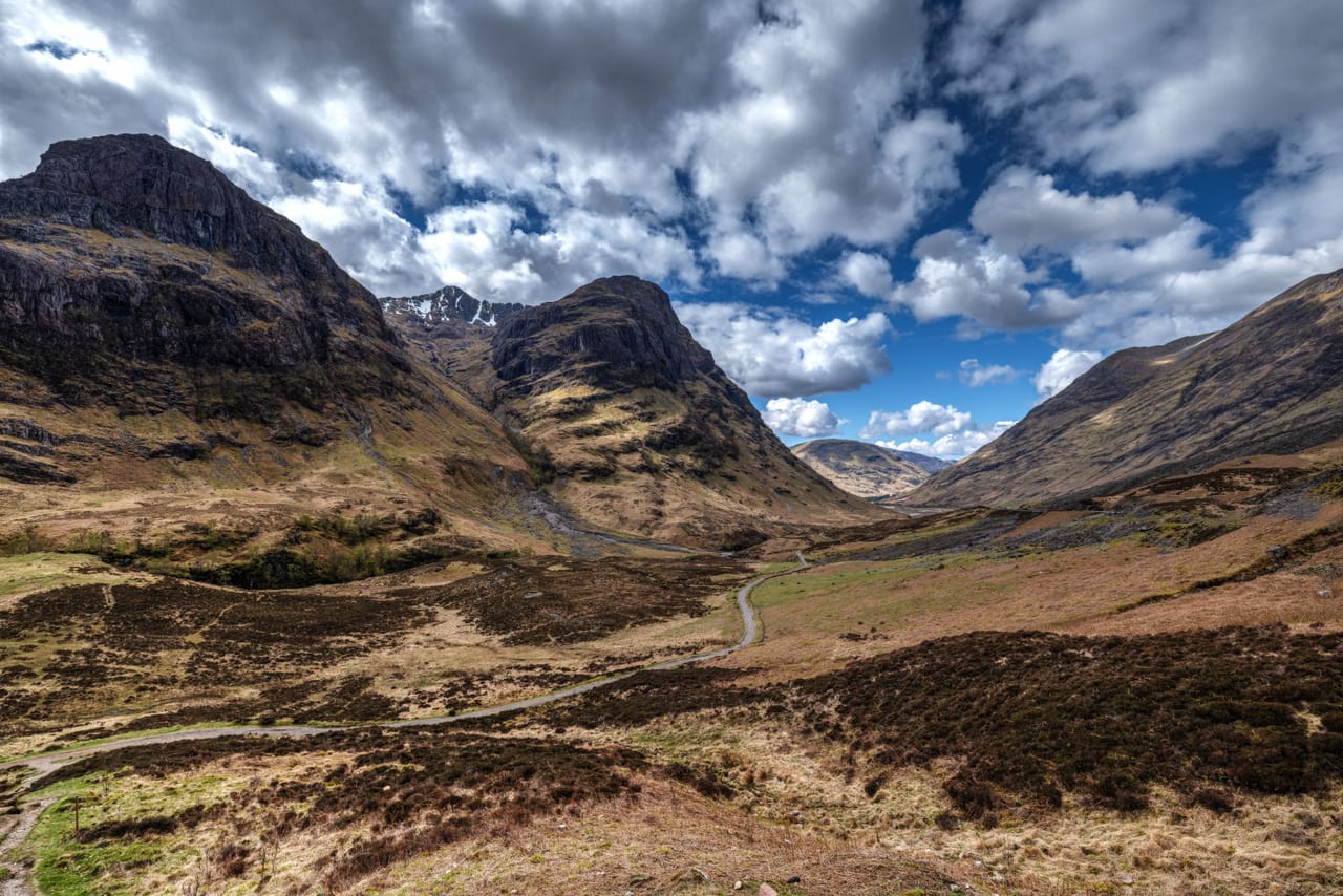 La vallée de Glencoe, ses montagnes et ses landes sous un grand ciel à nuages.