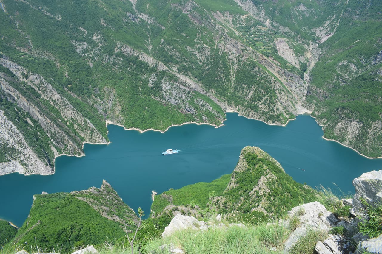Le lac de Koman serpente au fond de ses gorges, vu d’en haut.