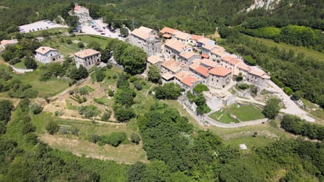 Hum et ses remparts au milieu des collines boisées.
