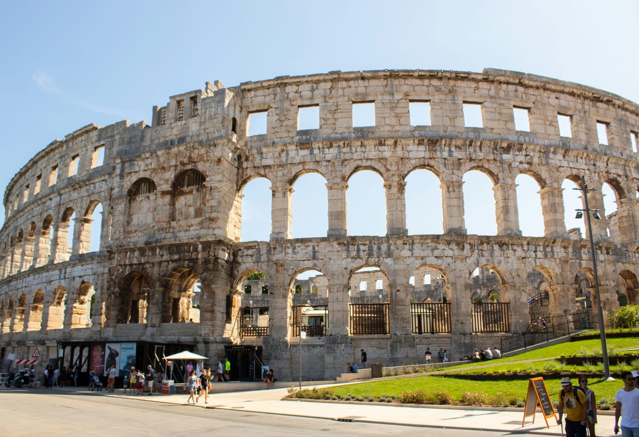 L’Arena de Pula et ses trois rangs d’arcades, sous un ciel bleu.