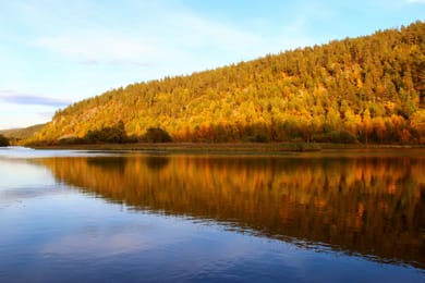 O rio Lemmenjoki entre encostas com as cores do outono.