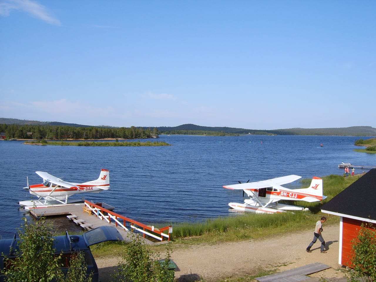 O lago Inari e as suas ilhas arborizadas, com hidroaviões atracados ao pontão.