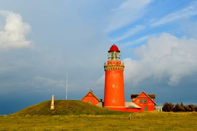 Le phare rouge de Bovbjerg, en entier, sur sa butte au-dessus de la mer du Nord.