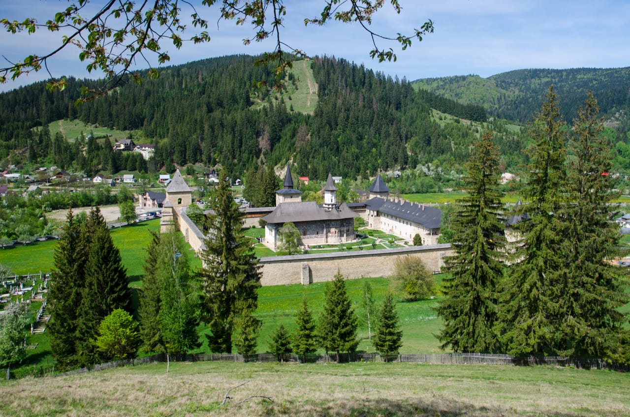 Le monastère de Sucevița dans sa vallée, entre prés et forêts de sapins.