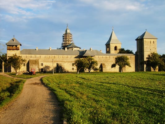 Le monastère fortifié de Dragomirna en fin de journée, au bout d’un chemin dans la prairie.