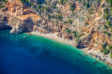 La plage de Pasjača vue du ciel, entre les falaises ocre de Konavle et l’eau turquoise.