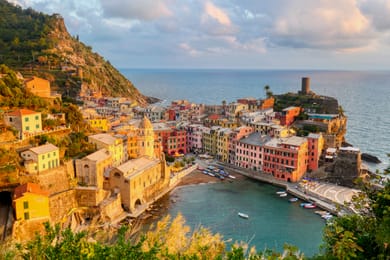 Vernazza en lumière dorée : le port, l’église Santa Margherita et la tour du château Doria.