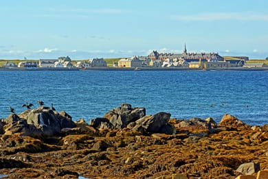 La forteresse de Louisbourg et ses toits au bord de la baie, vue de l’autre rive.
