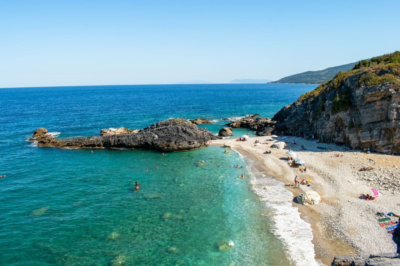Une plage de galets du Pélion, ses rochers et son eau turquoise au pied de la côte.