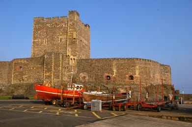 Le donjon de Carrickfergus et des bateaux de pêche sur le port.