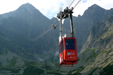 La cabine rouge du téléphérique de Lomnický štít, au-dessus d’un cirque rocheux.
