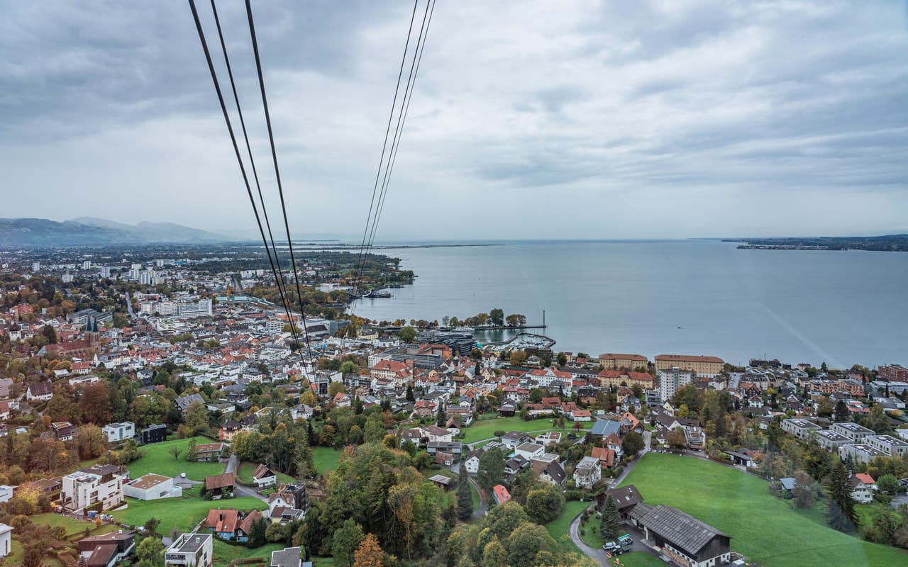 Bregenz et le lac de Constance vus de la cabine du téléphérique du Pfänder, entre les câbles.