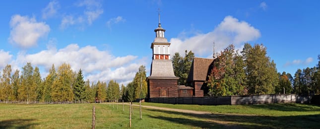 La vieille église en rondins de Petäjävesi et son clocher, en entier, sous le ciel bleu.