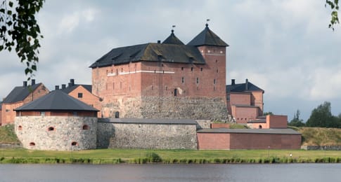 Le château de Häme, en brique rouge, au bord du lac Vanajavesi.