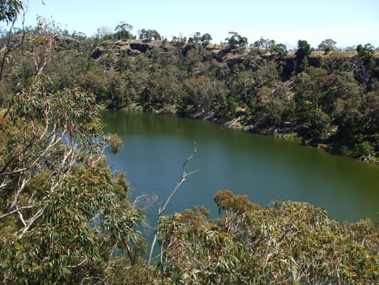 Le lac de cratère de Budj Bim, entre des pentes couvertes d’eucalyptus.