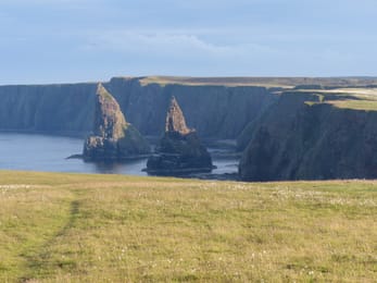 Les aiguilles de Duncansby devant les falaises du Caithness.