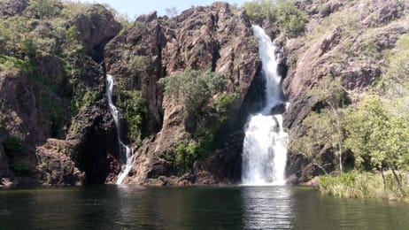 Les deux chutes de Wangi sur leur paroi de roche rouge, au-dessus du bassin.