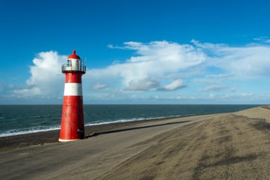 Le petit phare rouge et blanc de Westkapelle sur la digue, face à la mer.