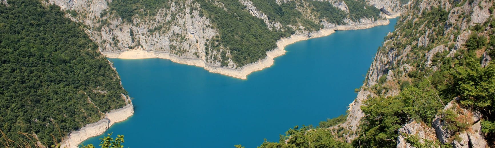 Le lac de Piva au fond de son canyon boisé.