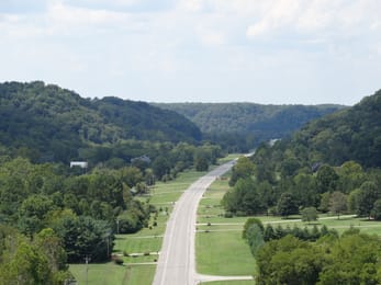 La Natchez Trace Parkway entre les collines boisées.