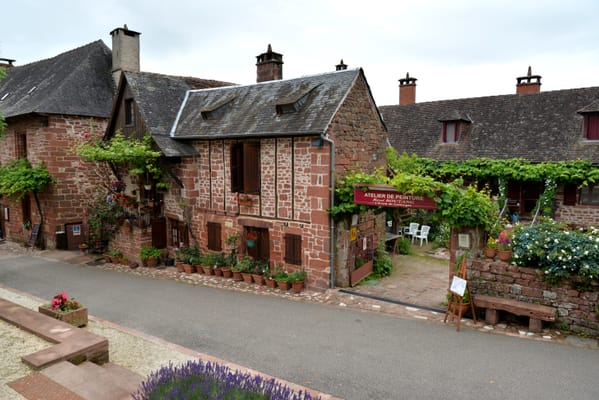 Une rue de Collonges-la-Rouge, ses maisons de grès rouge et ses jardinets fleuris.