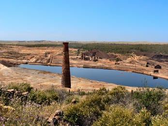 La mine de São Domingos : une cheminée de brique, la lagune acide et les terres ocre des haldes.
