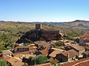 Sortelha : ses toits de tuiles rouges au pied du château, perché sur son éperon de granit.