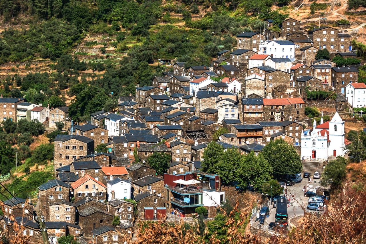 Piódão en amphithéâtre sur la pente de la Serra do Açor : maisons de schiste, terrasses et église blanche.