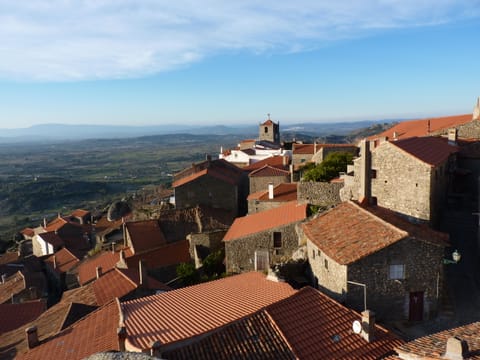 Monsanto, ses toits de tuiles et ses maisons de granit accrochés au rocher, au-dessus de la plaine de la Beira Baixa.