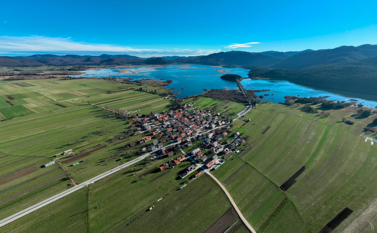 Le lac intermittent de Cerknica en eau, au-delà du village de Dolenje Jezero, vu du ciel.