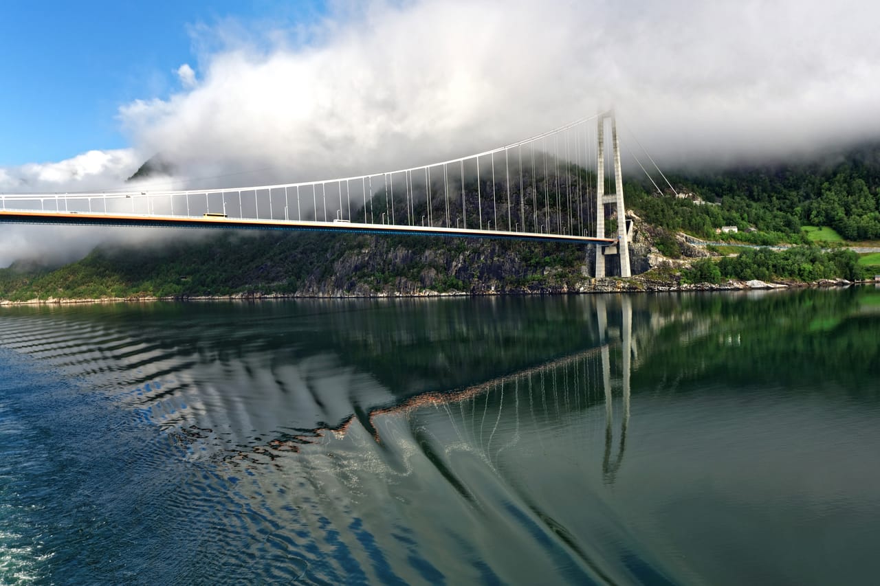 Le pont du Hardanger dans la brume du matin, reflété dans le fjord.
