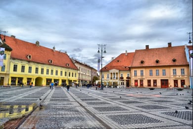 Les façades colorées et les toits rouges de la Grande Place de Sibiu.