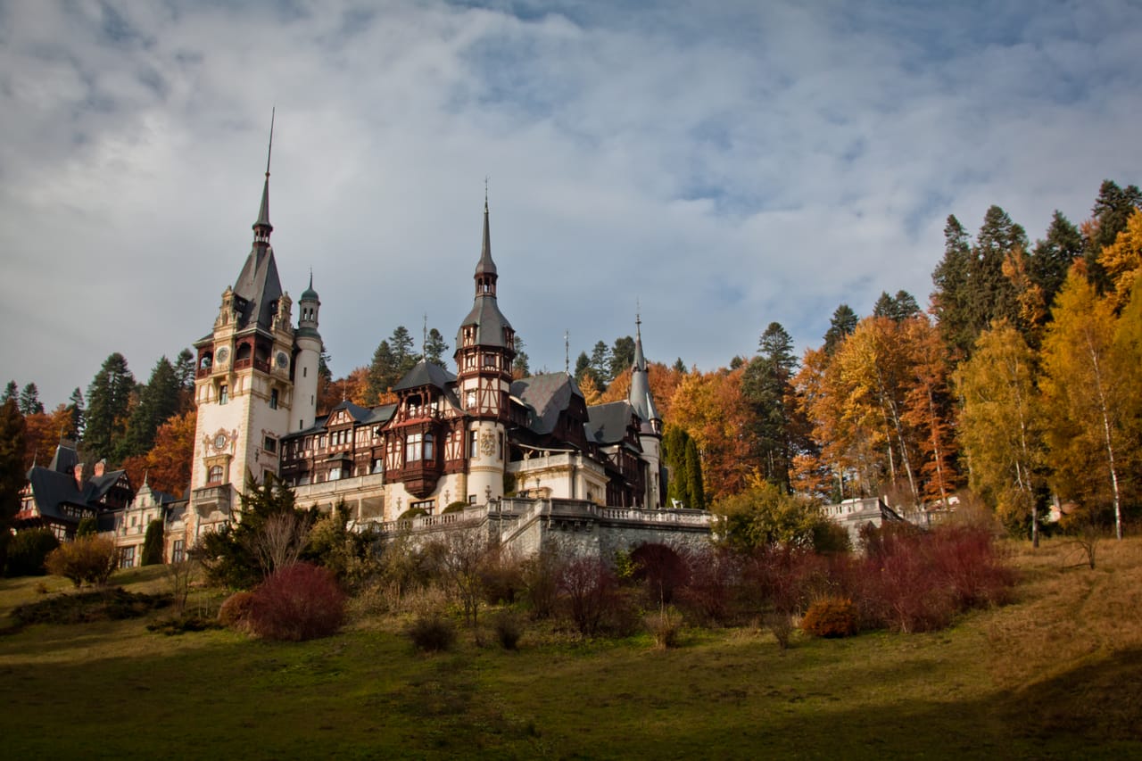 Le château de Peleș au bout de sa prairie, dans les couleurs de l’automne.