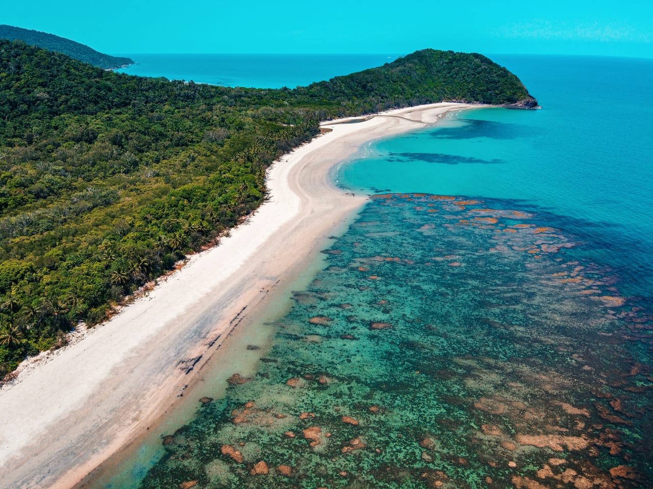 Au cap Tribulation, la forêt tropicale rencontre la plage et le récif turquoise, vus du ciel.