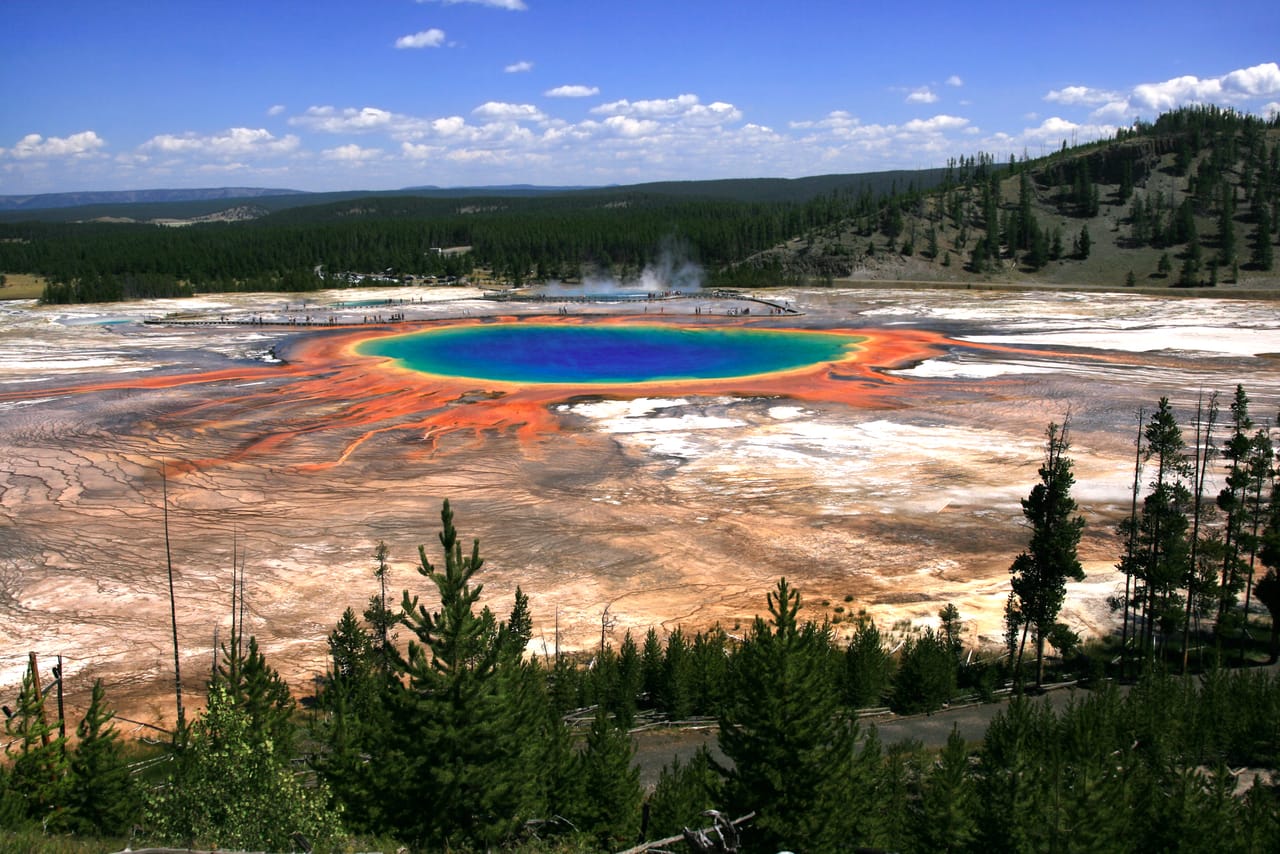 A Grand Prismatic Spring vista de cima, com a sua bacia azul rodeada de laranja.