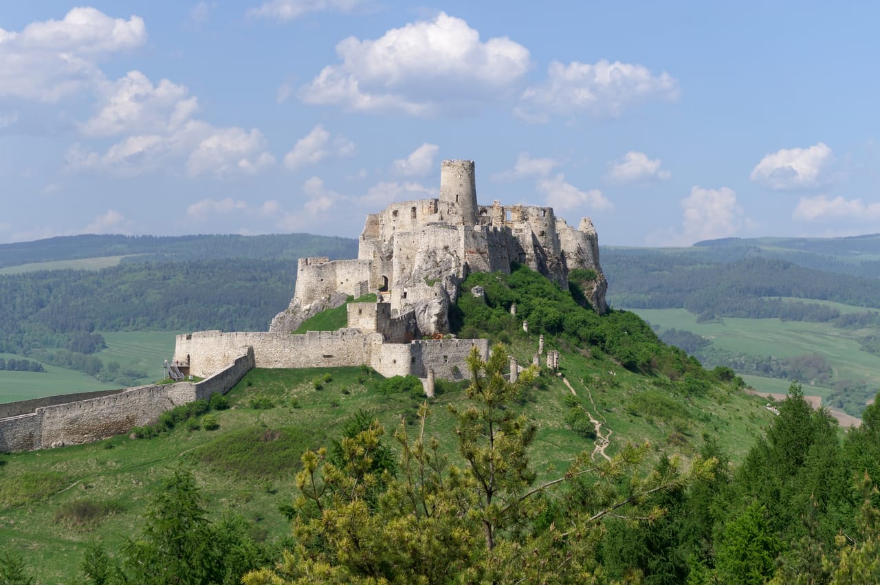 Le château de Spiš sur sa colline calcaire, au-dessus des prés et des forêts.