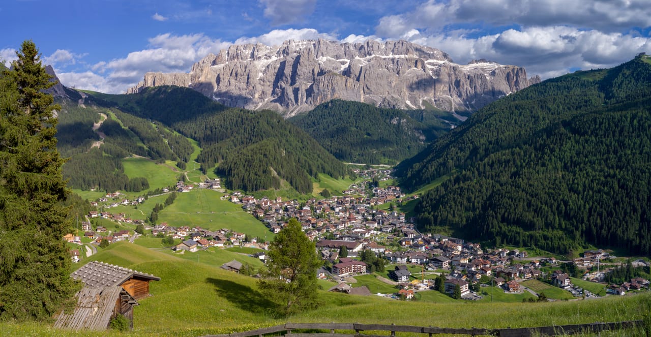 Selva di Val Gardena dans ses prés, sous le groupe du Cir et la muraille nord du Sella.