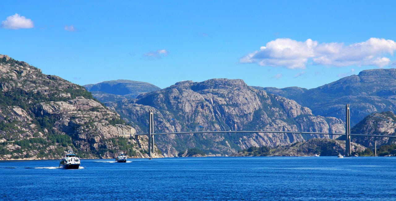 L’entrée du Lysefjord et son pont suspendu, entre les montagnes de granite, sous un ciel bleu.