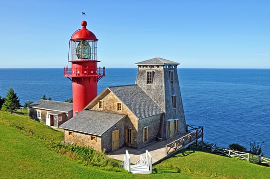 Le phare rouge de Pointe-à-la-Renommée et ses bâtiments au-dessus du golfe.